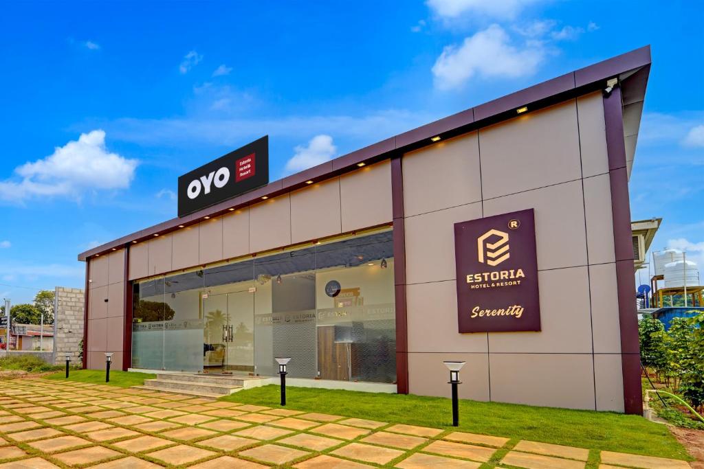 a store front of a building with a sign on it at Hotel O ESTORIA HOTEL & RESORT in Kadakola