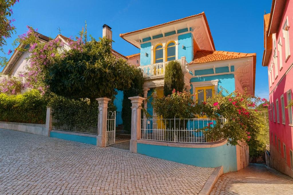 a blue house with flowers on a street at Happy Holiday Sintra in Sintra