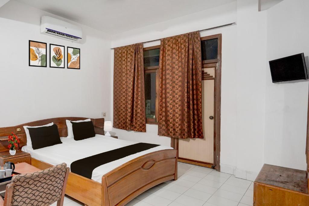 菩提伽耶Hotel O Buddha Statue Gaya Formerly Uruvela International的一间带床、电视和窗户的卧室