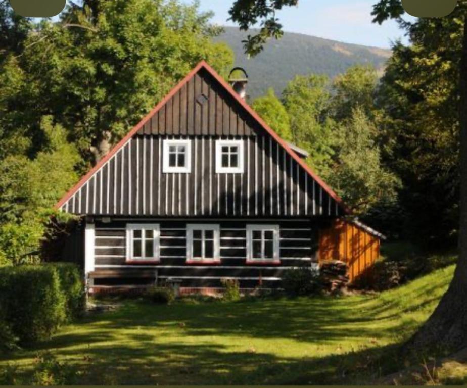 a large wooden house with a gambrel roof at Kouzelná chalupa u lesa in Česká Lípa