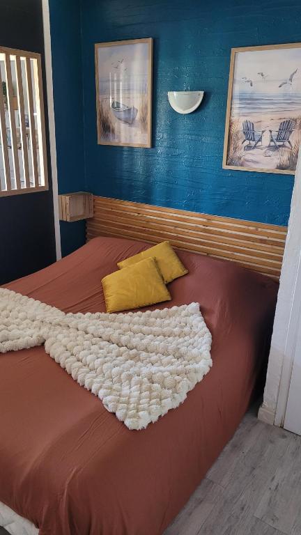 een bed met een rood dekbed en gele kussens bij LE MAS SYNAE in Sainte-Maxime