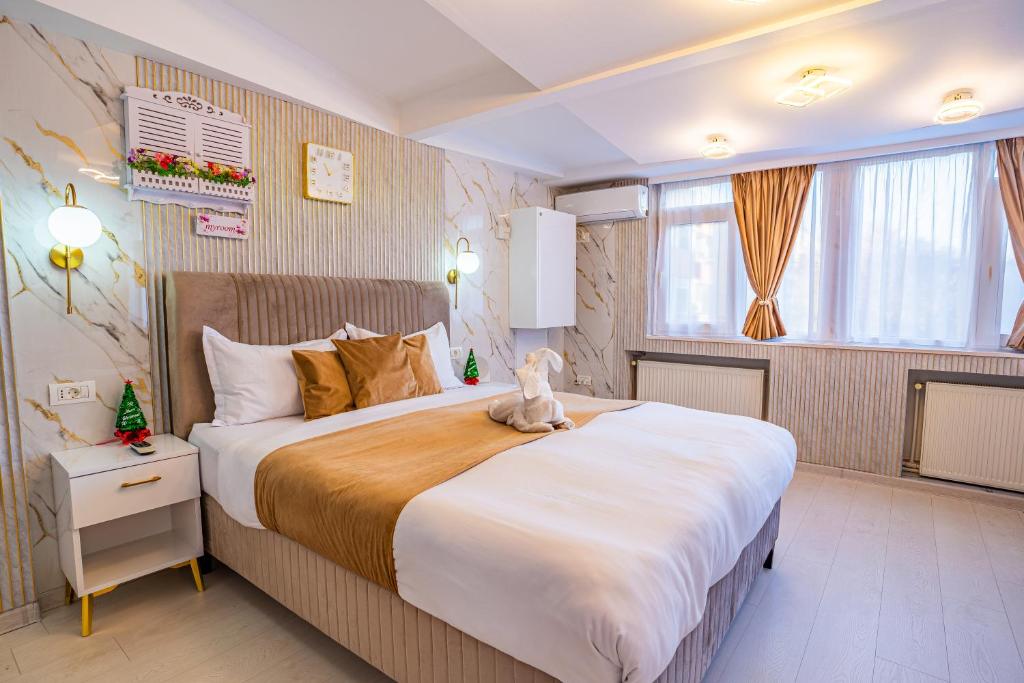 Iancu Jianu Premium Stay Apartment في بوخارست: غرفة نوم بسرير كبير عليها حشره محشوة