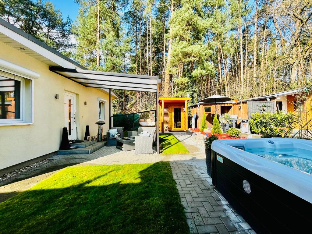 una casa con una vasca idromassaggio in giardino di Natur & Wellness Ferienhaus Garden a Siedlung Bergheide