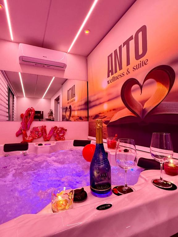 a hot tub with a bottle of wine and glasses at ANTO Wellness & Suite in Nova Siri Marina