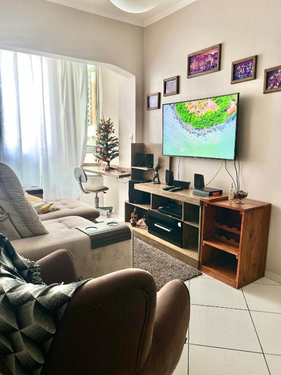 a living room with a couch and a flat screen tv at Apartamento completo no centro da cidade in Passo Fundo