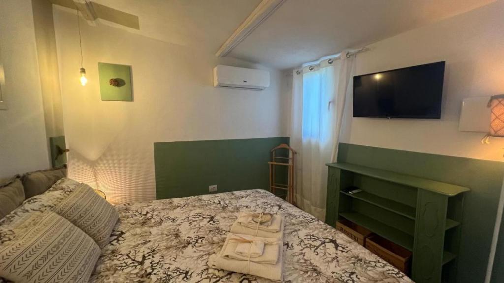 Camera di Zio Peppe- Vintage Room في سانتا تيريزا غالّورا: غرفة نوم مع سرير وتلفزيون على الحائط