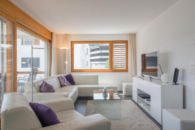 a living room with a couch and a tv at Edelweiss Casa Cassons in Flims
