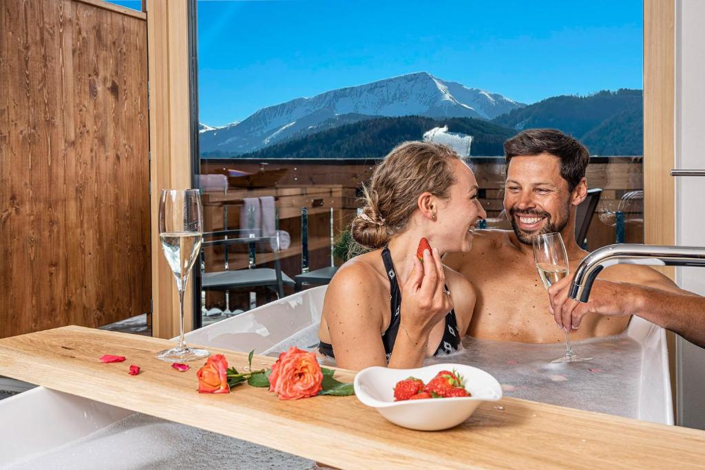 a man and a woman sitting in a bath tub at Chalet Schlossberg Schwarzhorn in Nova Ponente