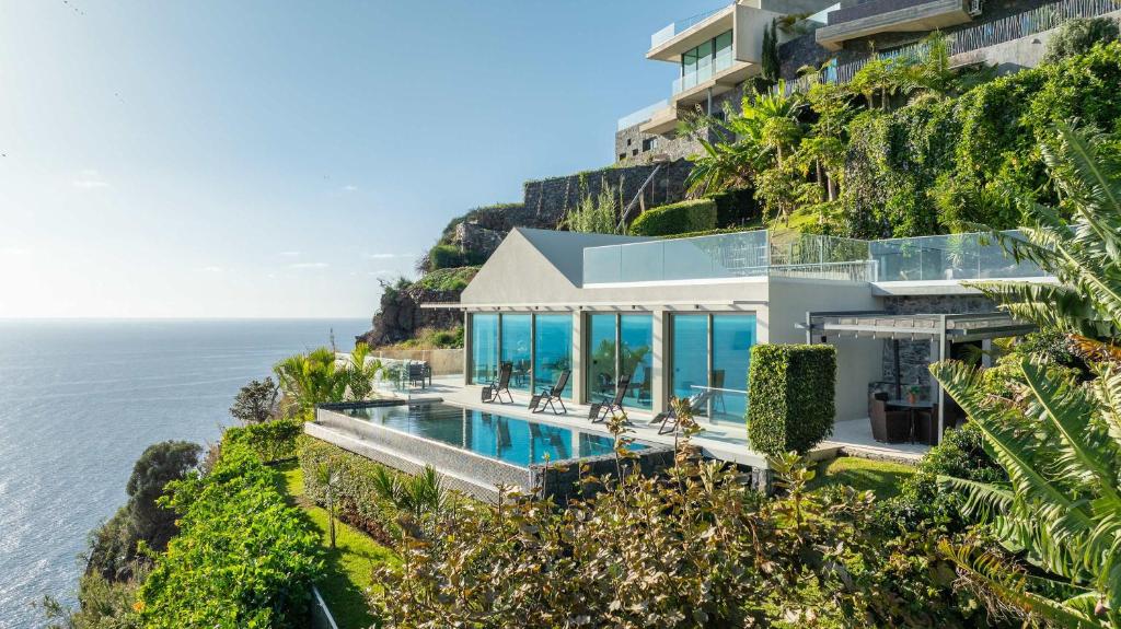 eine Luftansicht eines Hauses auf einer Klippe neben dem Meer in der Unterkunft Villa CLIFF HEAVEN HOUSE in Calheta