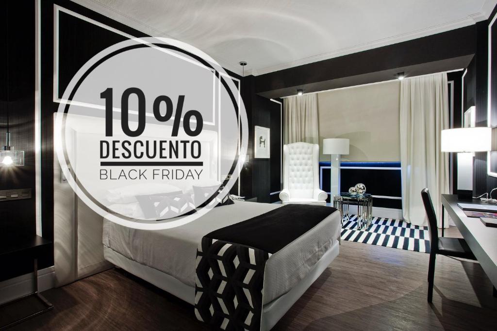um quarto preto e branco com uma cama e um espelho em Hotel Tres Reyes Pamplona em Pamplona