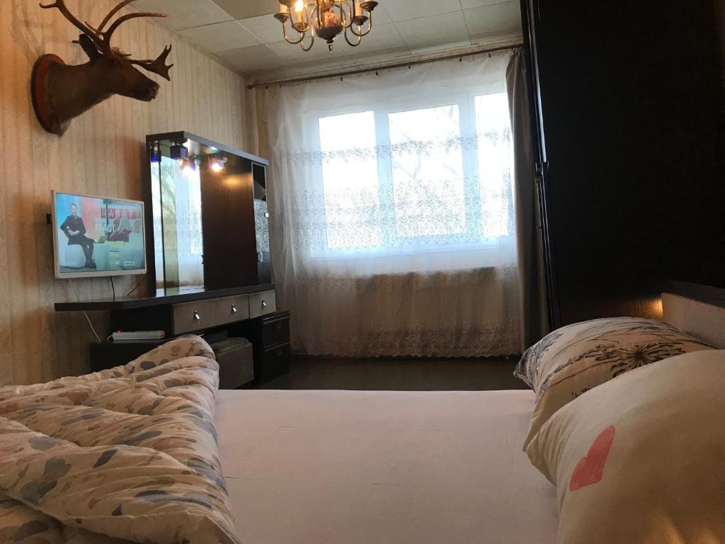 a bedroom with a bed and a mirror and a window at Casa del Cervo in Chişinău