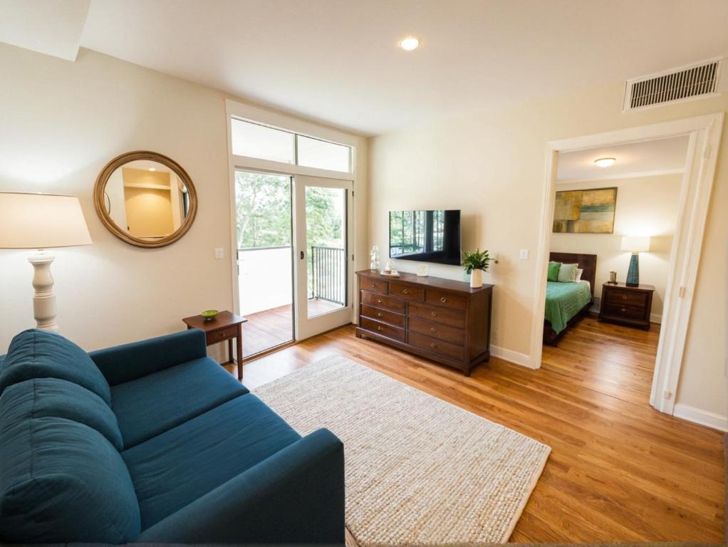 a living room with a blue couch and a bedroom at Boutique KTown Stays With Breathtaking Rooftop Views in Los Angeles