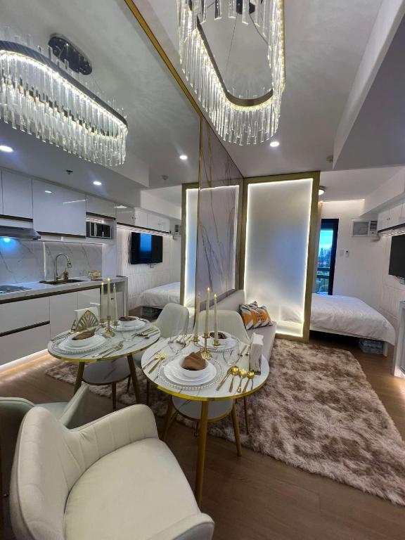 a living room with two tables and a kitchen at Belle Maison in Pine Suites Tagaytay in Tagaytay