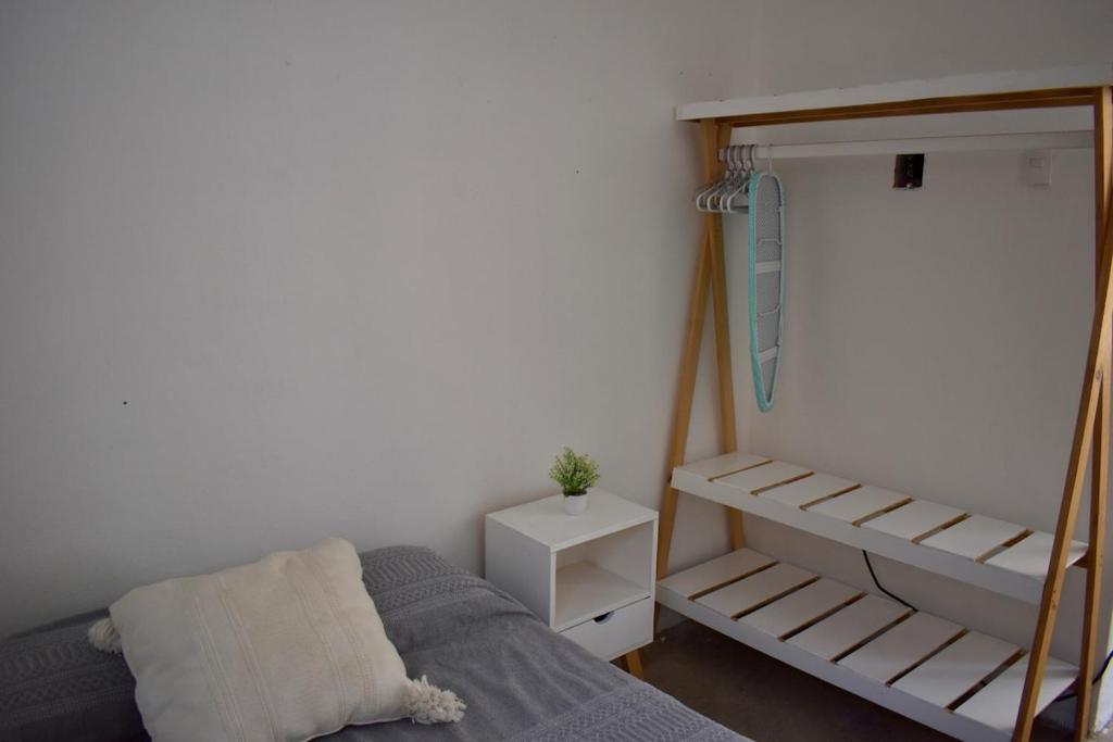 a small bedroom with a bed and a book shelf at Casita en el centro de Oaxaca cerca de Santo Domingo in Oaxaca City