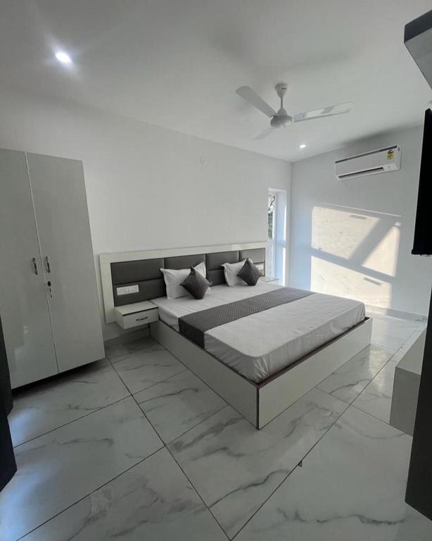 a white bedroom with a bed and a ceiling at Sky s whiye house in Ludhiana