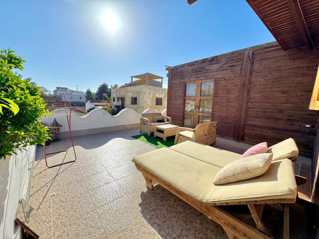 um pátio com um sofá e cadeiras numa varanda em wooden house Dahab em Dahab