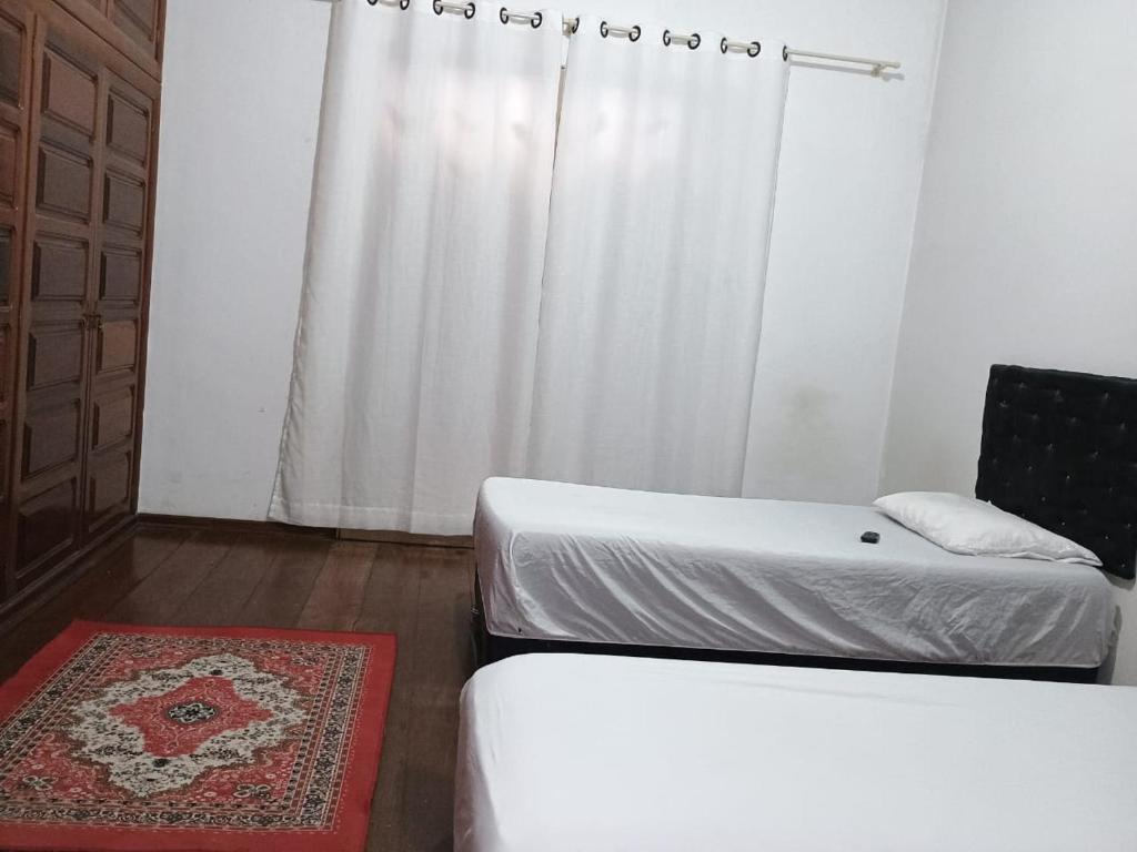 una camera con due letti e una sedia e una finestra di Hotel luxus d cor a Porto Ferreira