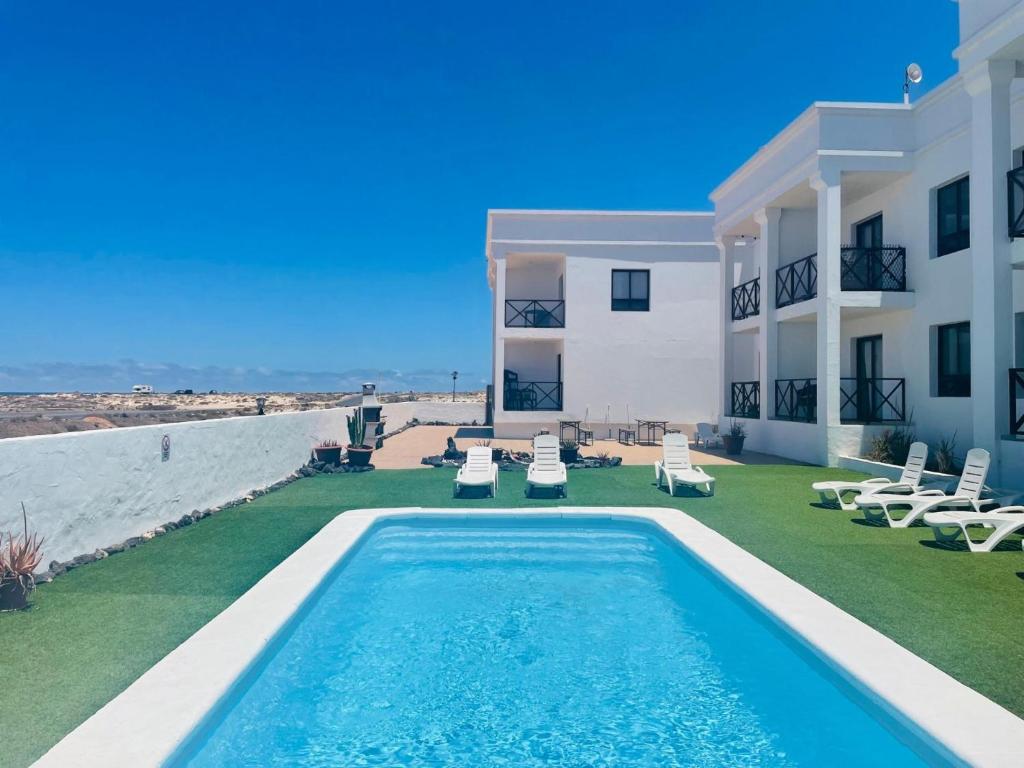 a villa with a swimming pool and a building at Ola Cotillo Beach El Cotillo in El Cotillo