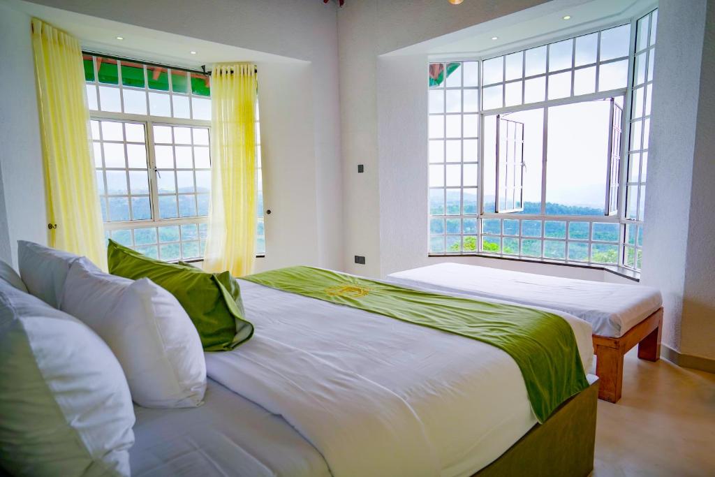 una camera da letto con due letti e una grande finestra di The Colonial Crest a Nillambe