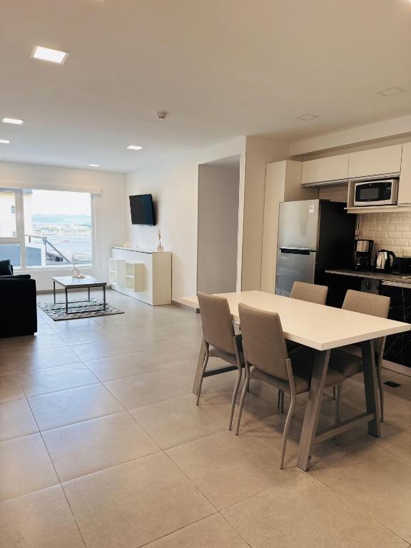 a kitchen and living room with a table and chairs at Gente del Sur - Avenida in Ushuaia