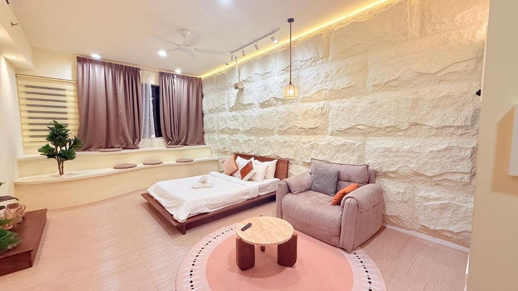 een woonkamer met een bank en een bed bij Chamber service Suites Kuala Lumpur in Kuala Lumpur