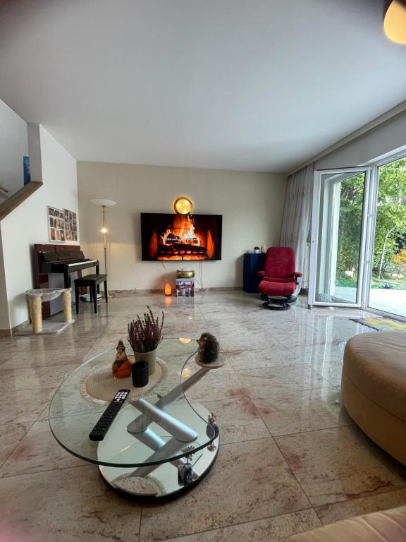 a living room with a glass table and a fireplace at Wohlfühlhaus mit Jacuzzi, Fitness, Infrarotkabine, Kamin, Piano, tolle Lage in Vienna