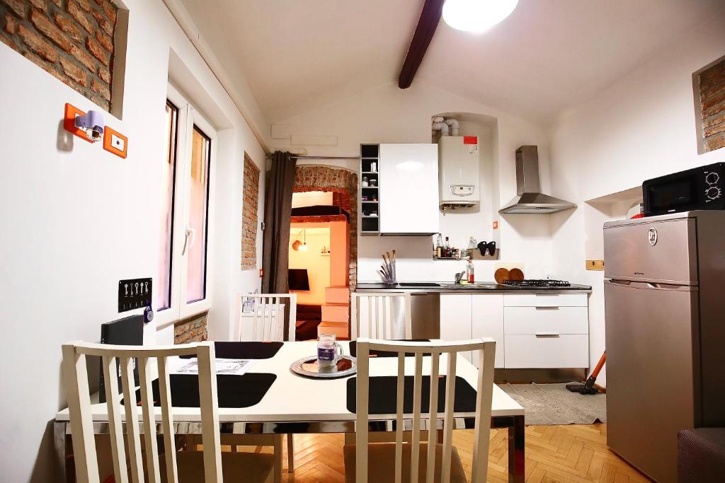 una cucina con tavolo, sedie e frigorifero di Penthouse in central Milan a Milano