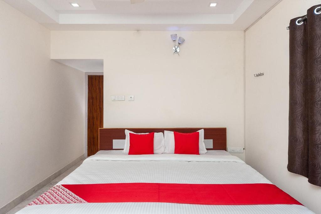 a bedroom with a bed with red pillows at Super Hotel O Le Mint OMR in Chennai