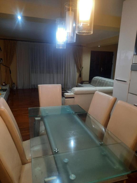 ein Esszimmer mit Glastisch und Stühlen in der Unterkunft AlexandraMihai in Craiova