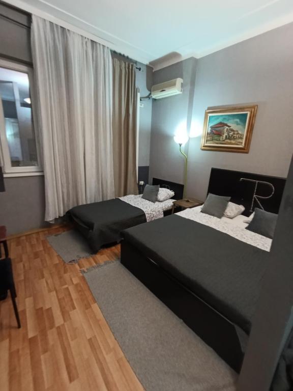 a bedroom with two beds and a window at Топ соба 2 in Niš