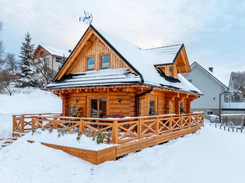 una baita di tronchi nella neve di Dobry Lot - Agroturystyka a Koniaków