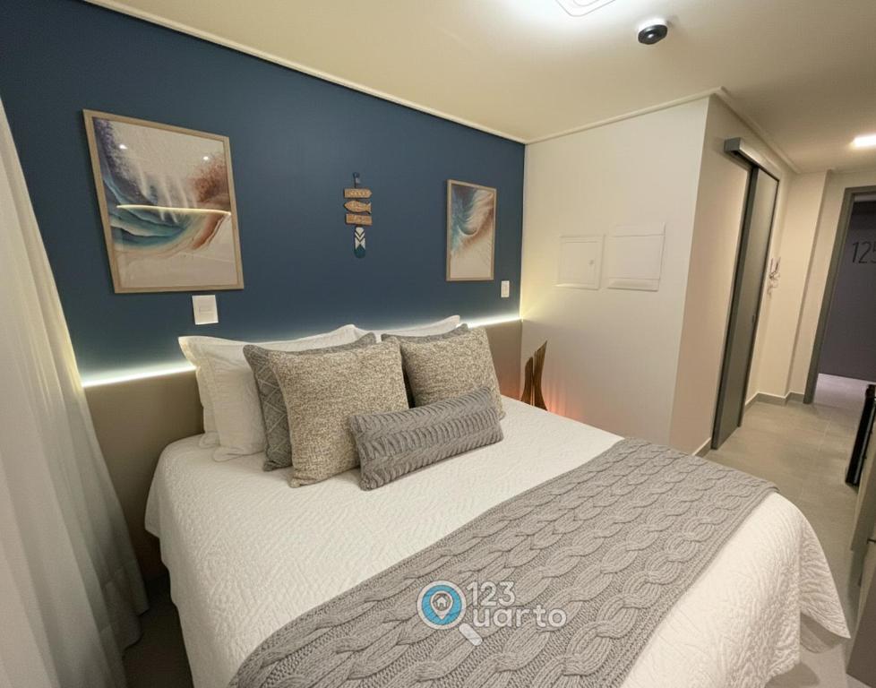 een slaapkamer met een groot bed met een blauwe muur bij Hit Cabo Branco by 123Quarto in Tambaú