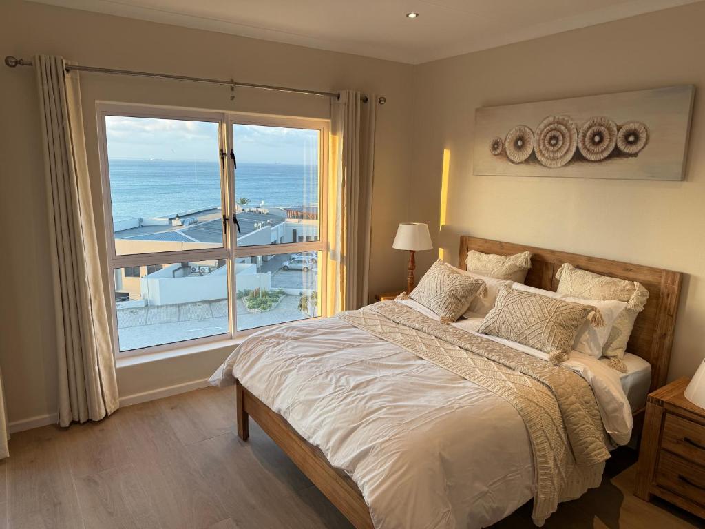 ein Schlafzimmer mit einem Bett und einem großen Fenster in der Unterkunft Beach view Apartment in Gqeberha