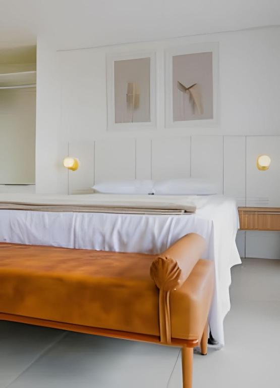 a bedroom with a bed and a bench at Stay Pure | Design Clean e Atmosfera Tranquila in Campo Grande