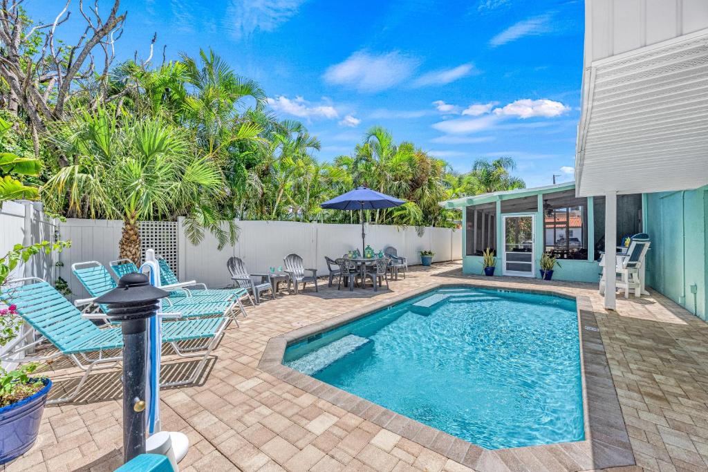 a patio with a swimming pool and chairs and a table at Plumbago - 5251C in Siesta Key