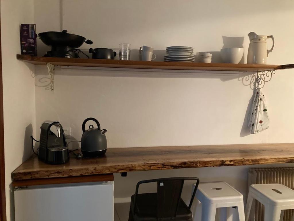 ヴェンゾーネにあるL'Intermezzoの鍋やフライパン、椅子が置かれたカウンターのあるキッチン