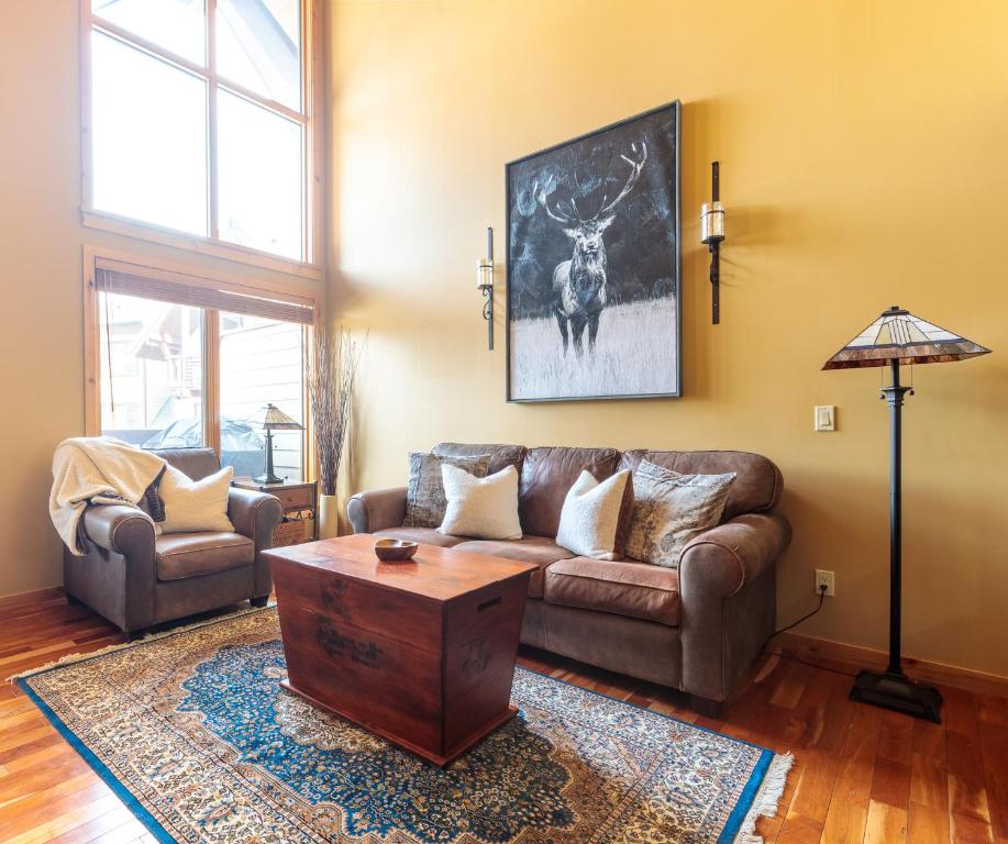 a living room with a couch and a table at Utopia at Rundle Cliffs Lodge in Canmore