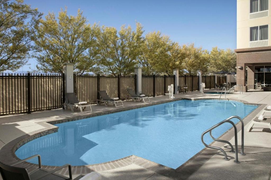 a large swimming pool with chairs and a fence at Fairfield Inn and Suites Phoenix Chandler Fashion Center in Chandler