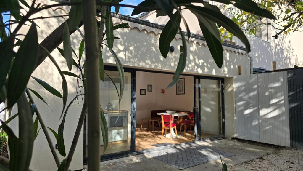 阿维尼翁Le MazeL, meublé de tourisme 2 à 4 personnes的玻璃门和桌子的房子