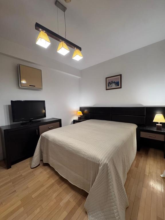 a bedroom with a bed and a flat screen tv at La Residenza in Craiova