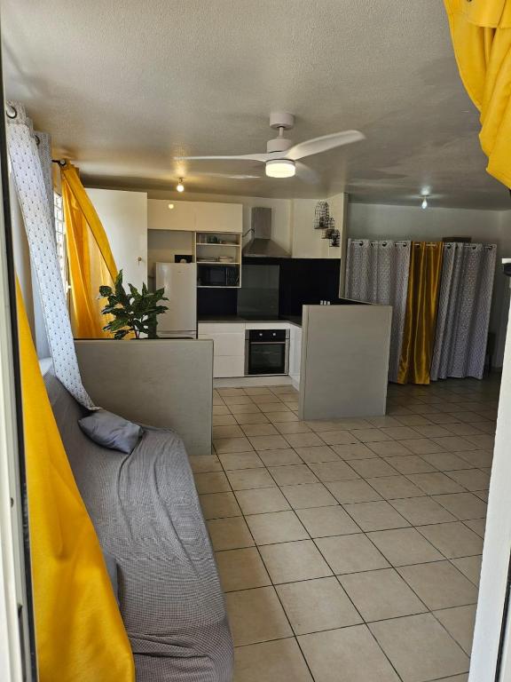 a kitchen and a living room with a couch and a kitchen at Évasion Soleil in Le Gosier