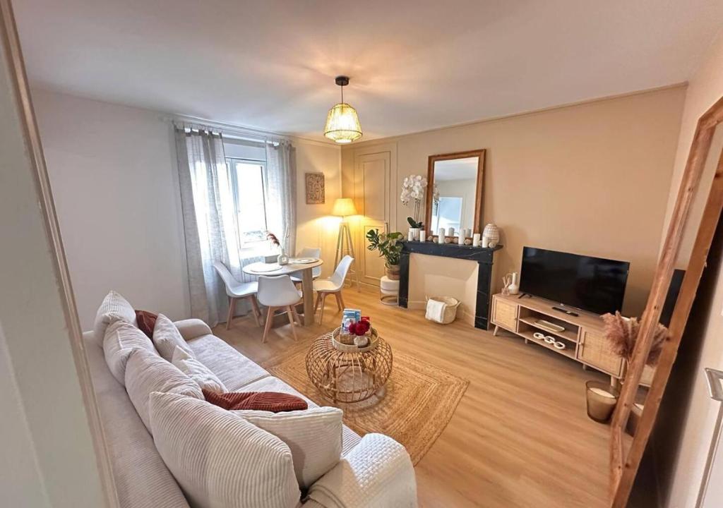 a living room with a couch and a table at Fleur Bohème - Hypercentre République - Parking in Le Mans