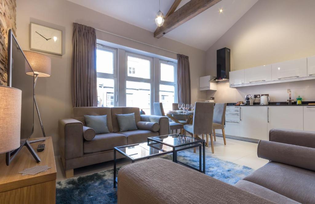 a living room with a couch and a table at Mansio Suites Basinghall in Leeds