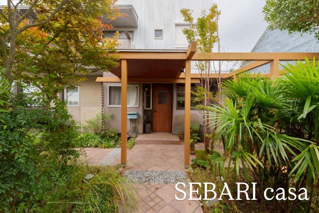 a house with a wooden door and a patio at SEBARI casa vacation rental in Kushima
