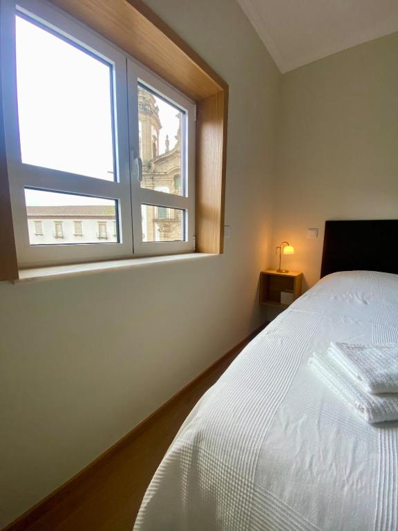 a bedroom with a white bed and a window at Casa do Mosteiro in Cabeceiras de Basto