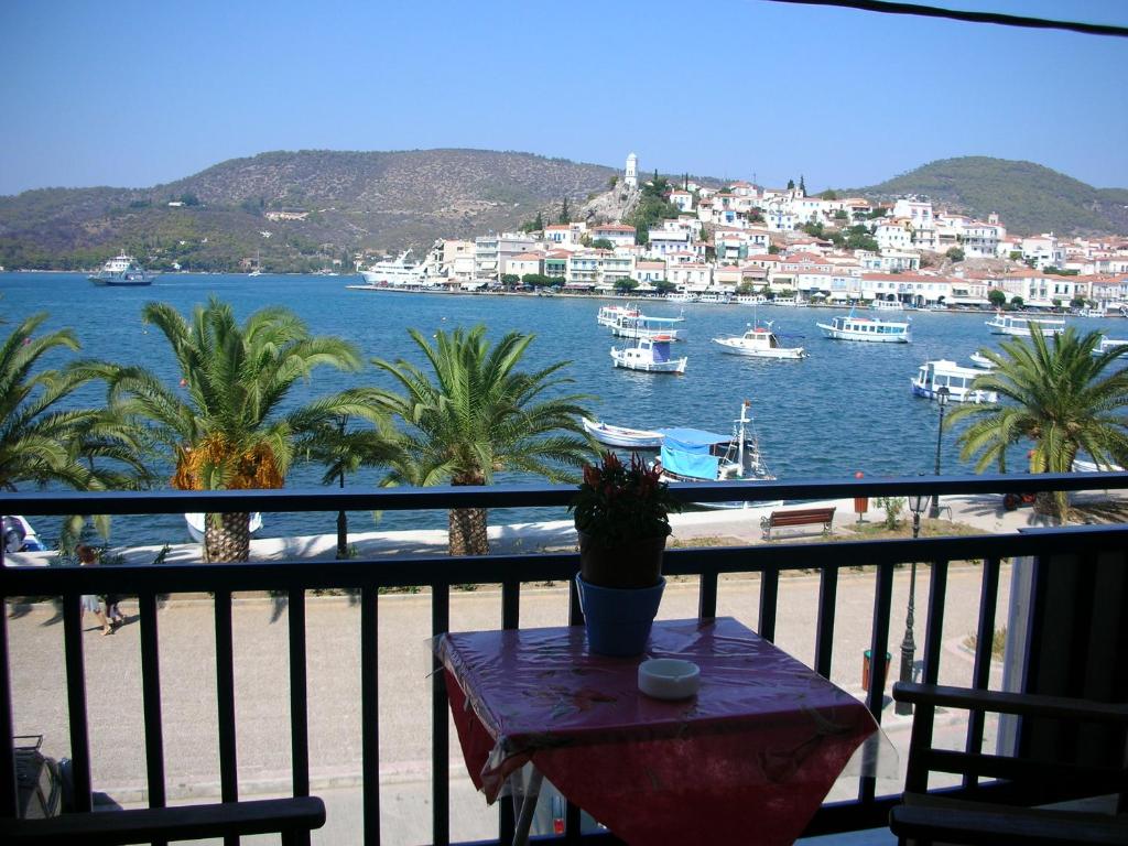 a balcony with a table and a view of a harbor at Bissias Guest House in Galatas