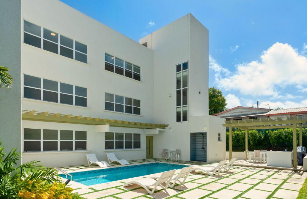 a large white house with a swimming pool at Walk to Mullins Beach Ground Floor Pool Fast WiFi in Saint Peter