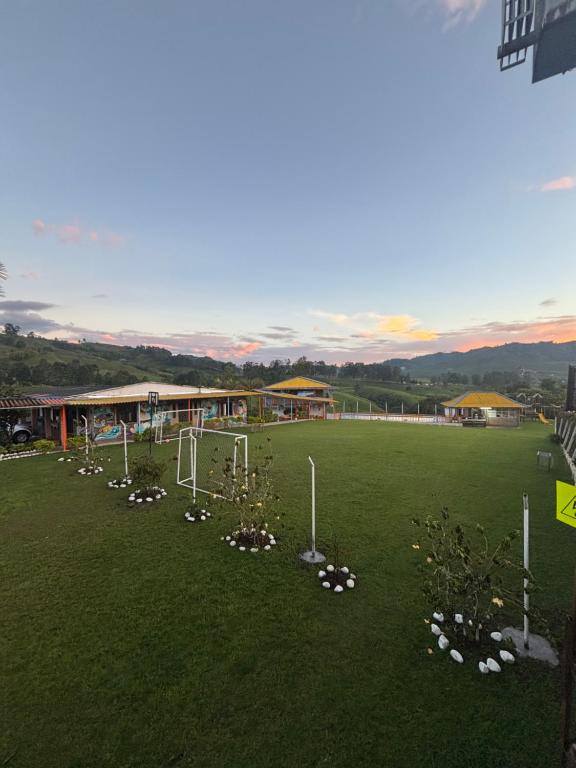 圣罗莎德卡瓦尔Finca Hotel La Fragata的一片绿地，上面有一栋建筑和一些鲜花。