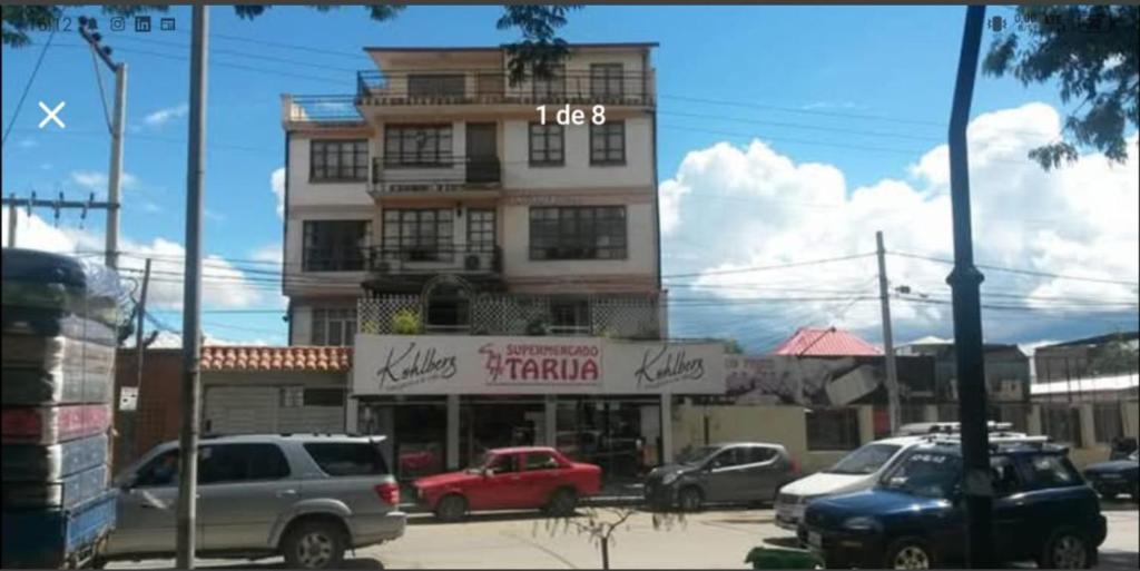 塔里哈Temporal Suit Tarija by Dolce Casa的一座高楼，停车场里停满了汽车