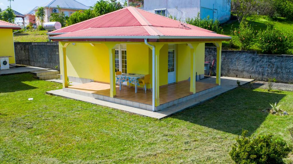 a small yellow gazebo with a red roof at Gîtes les fleurs du bananier in Goyave